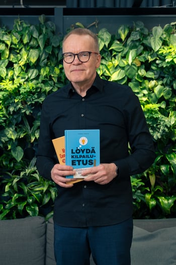 Markku-Vierula-hymyilee-kirjojensa-kanssa