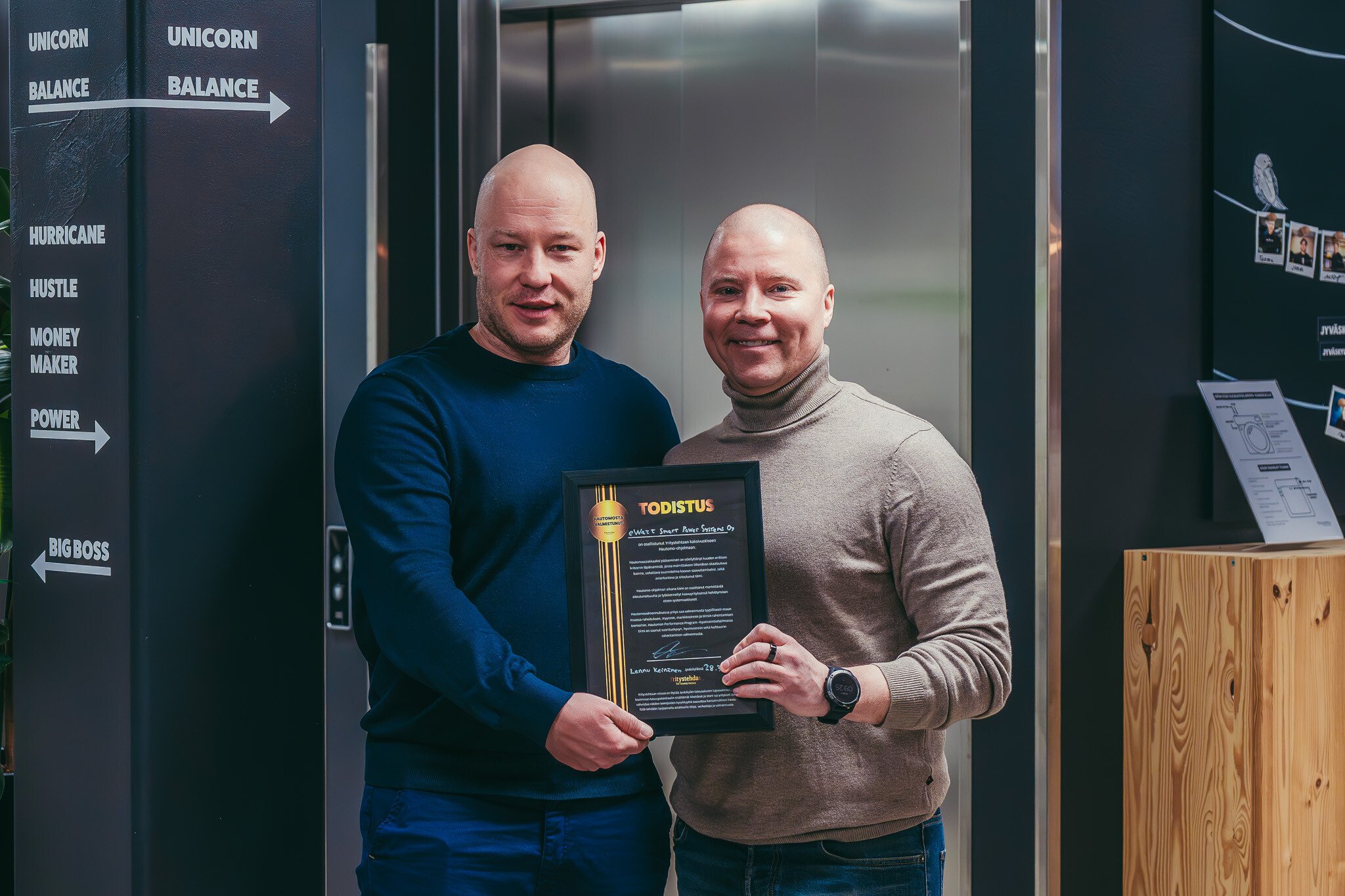 eWatt Smart Power Systems Oyn yrittäjä sekä yritystehtaan valmentaja yhteiskuvassa.